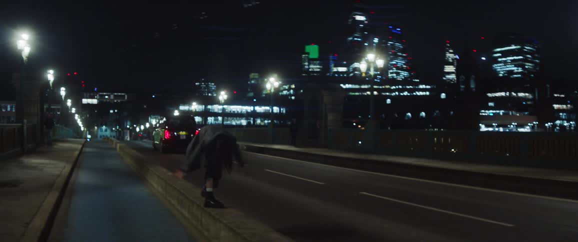 A woman is dancing in the street during the night