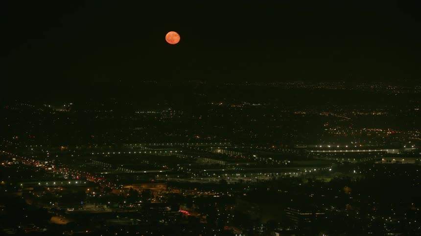 A city at night under a blood moon