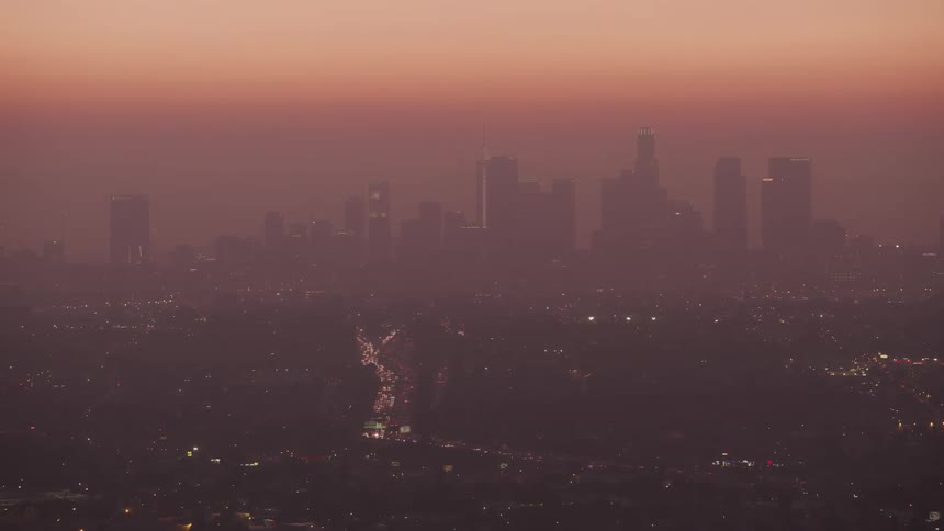 Red tinted fog obscures skyscrapers and busy highway