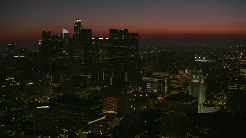 High rise buildings surround skyscrapers contrasting against red horizon
