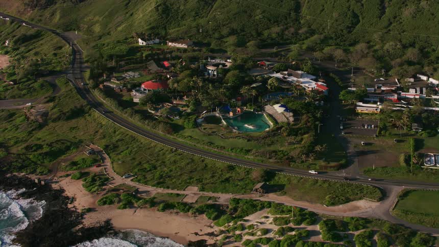 An aerial of a rural area with hosues next to a road along the coast