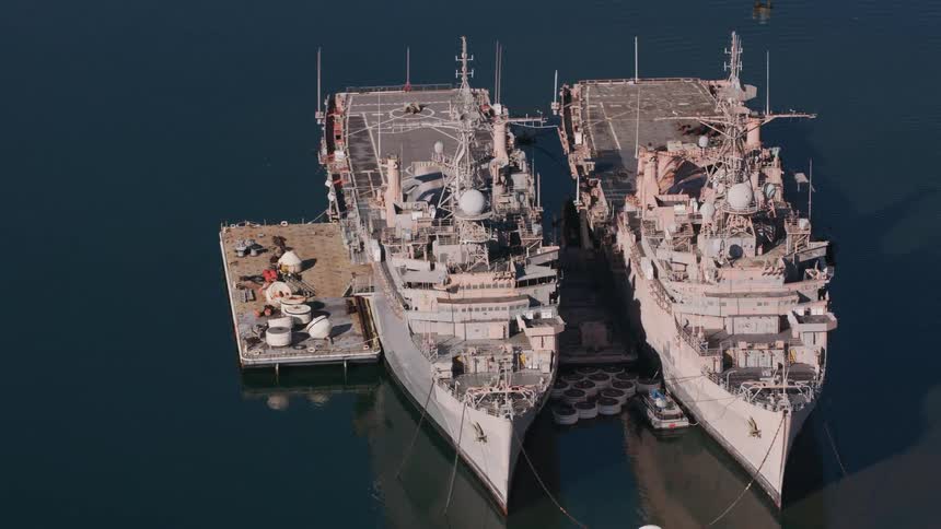 Two ships are in the ocean water during midday