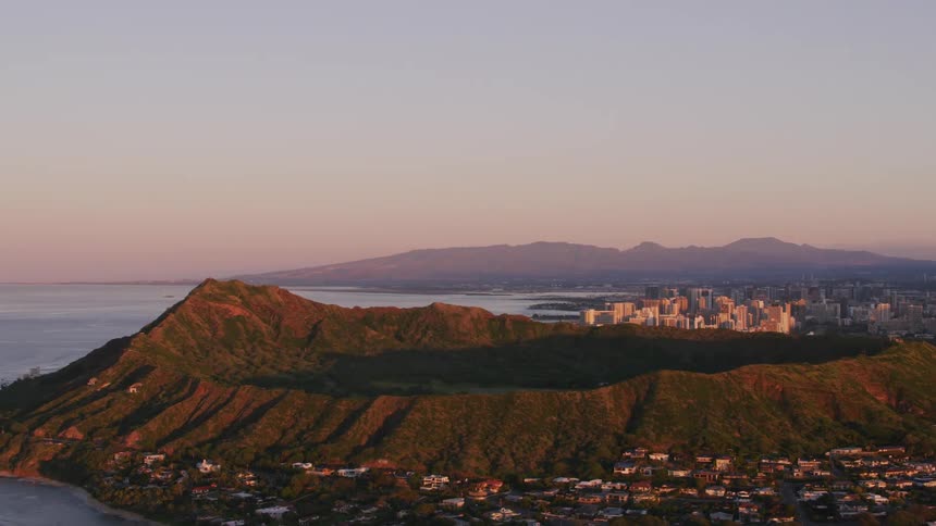 Large crater on coast separates residential area and city downtown under a red tinted horizon