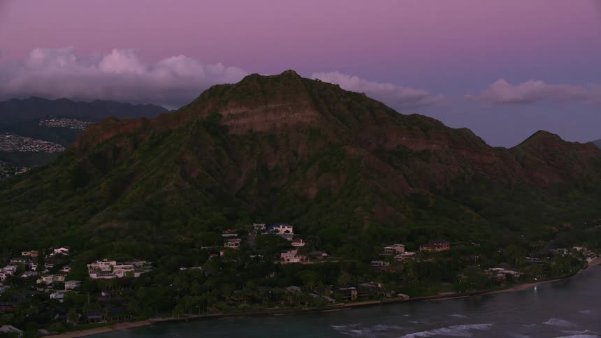 A city on the edge of an island next to a mountain