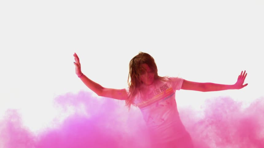 A young woman is falling through pink colored dust