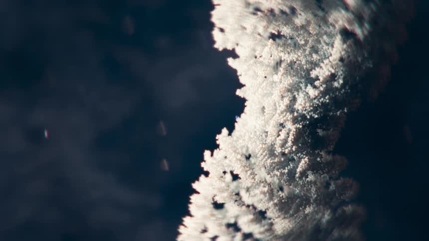 Bristling feathery white layered chromosome rotates near floating spots