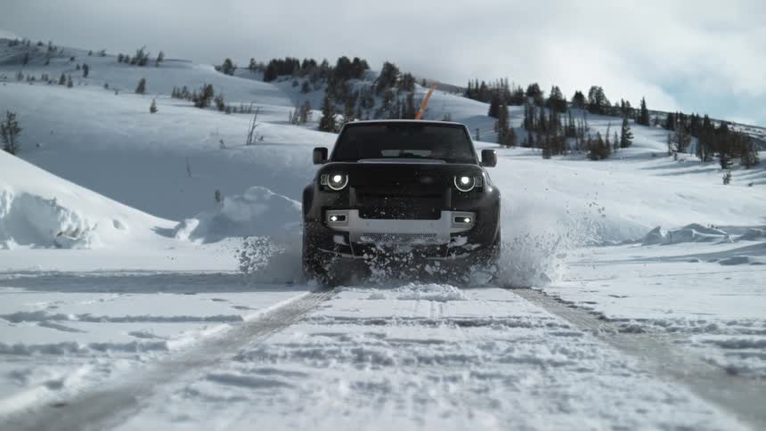An suv drives through a small pile of snow on the road destroying it