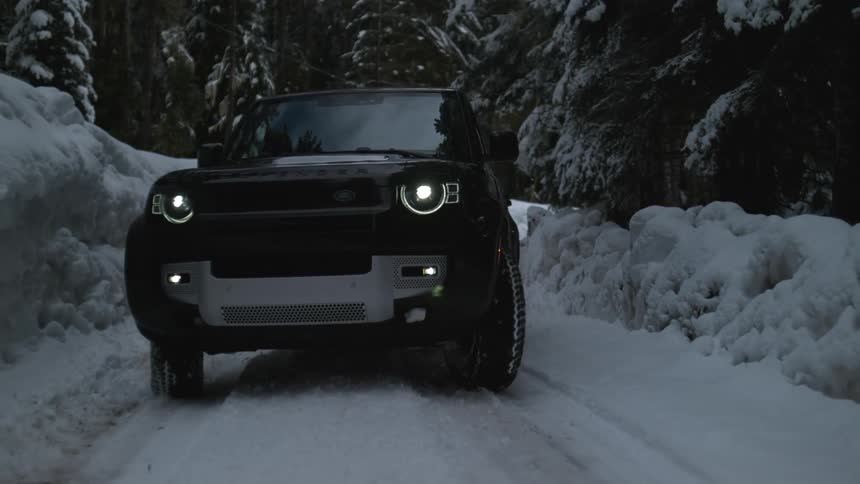 A sport utility vehicle drive through a snowy forest