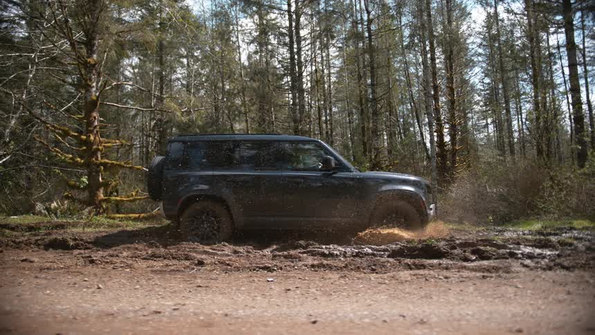 Black suv car driving on muddy road in the forest