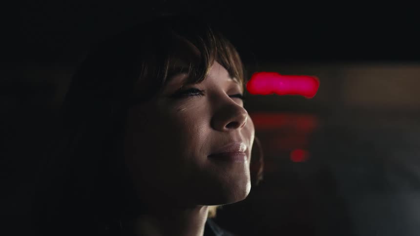 A woman smiles while looking up