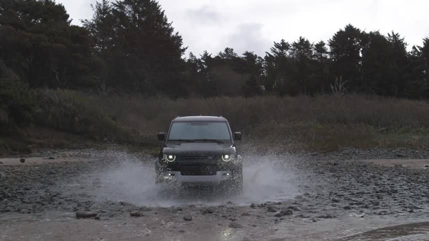 Black suv car drives on the coast on a cloudy day