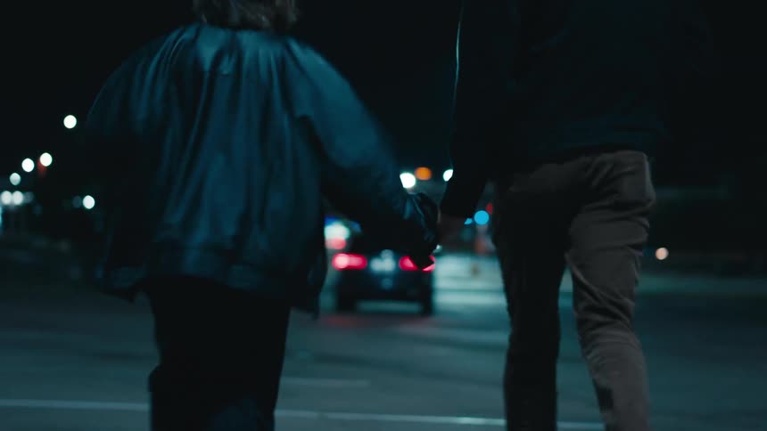 A man and womanhold hands while running down the street