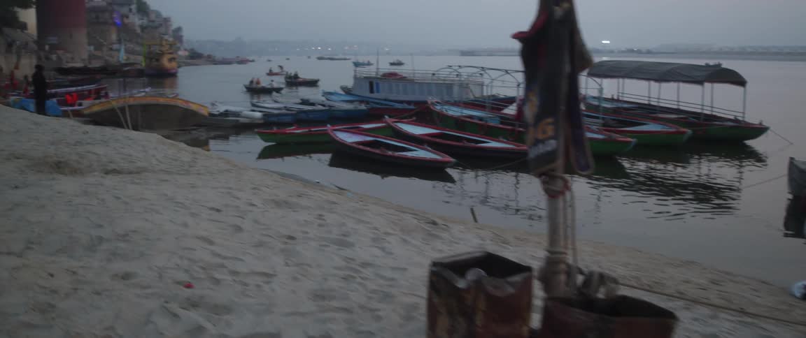 A sand pier in an indian city with multiple boats docked
