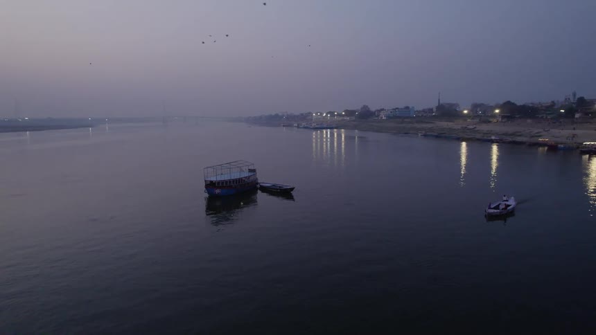 Boats and ferryboat float on water off the coast