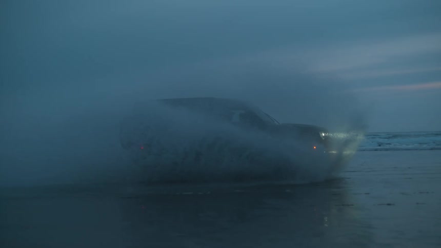 A sport utility vehicle drives through water