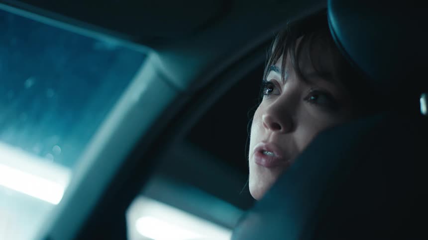 Woman sitting in car talks to person