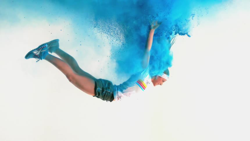A girl falling through a cloud of blue powder