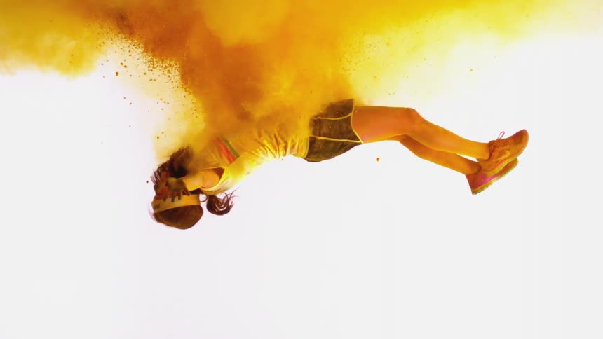 A girl is falling through a cloud of yellow powder