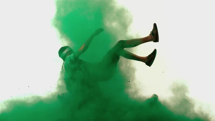 A young man emerges through a cloud of green powder