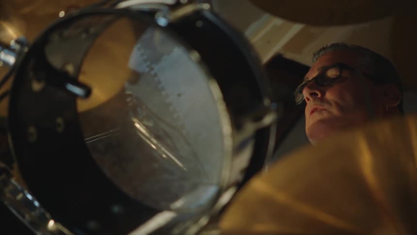 The bottom side of a drumset while a man plays it