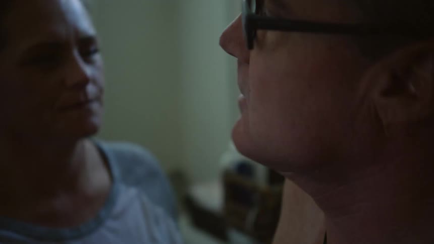 A woman puts skin cream on a mans face