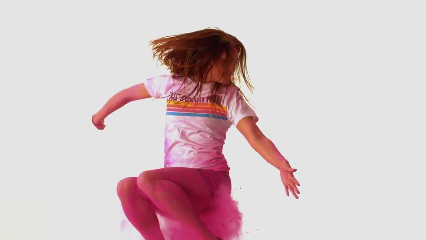 Girl jumping in slow motion with pink chalk around her
