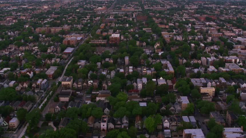 Aerial view of suburban area traveling forward across a neighborhood with apartment buildings and trees