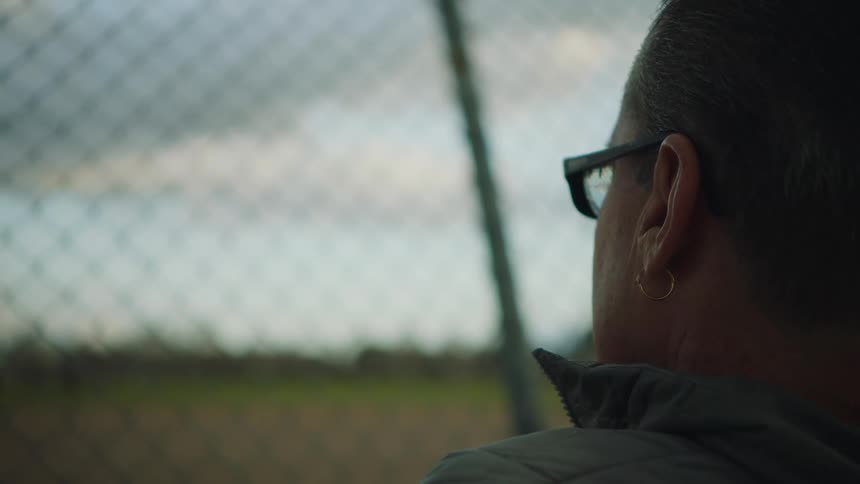 A woman is looking through the fence