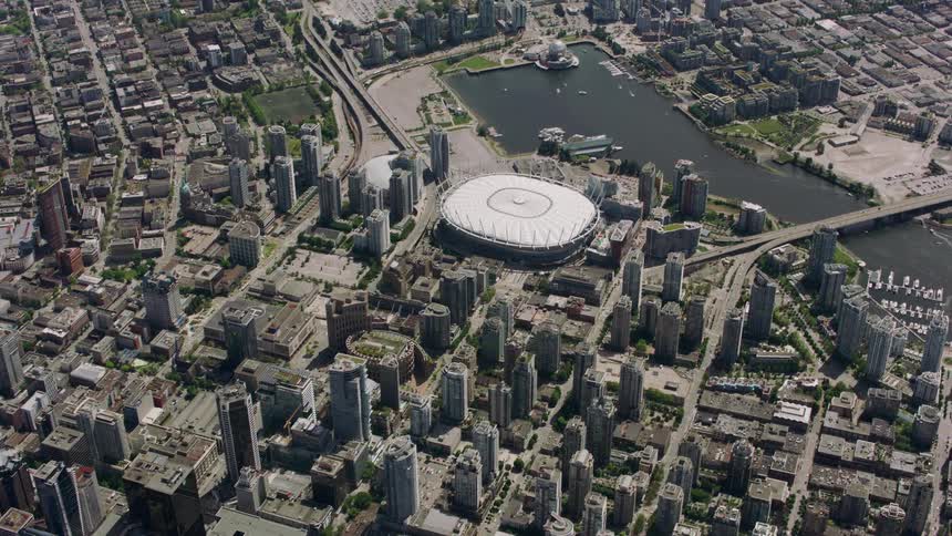 A sports arena and a lake in the center of a big city