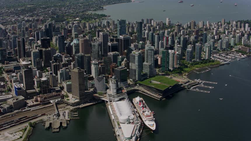 A large ship is by the city shore