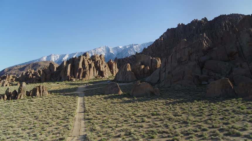 An aerial landscape of a desert land with roads and mountain ranges