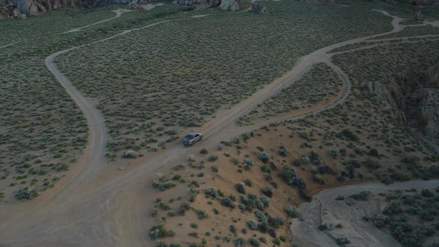 The truck is driving on the dirt trail