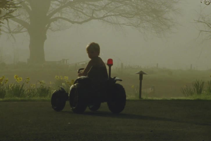 A young kid is outdoors in the middle of the day time