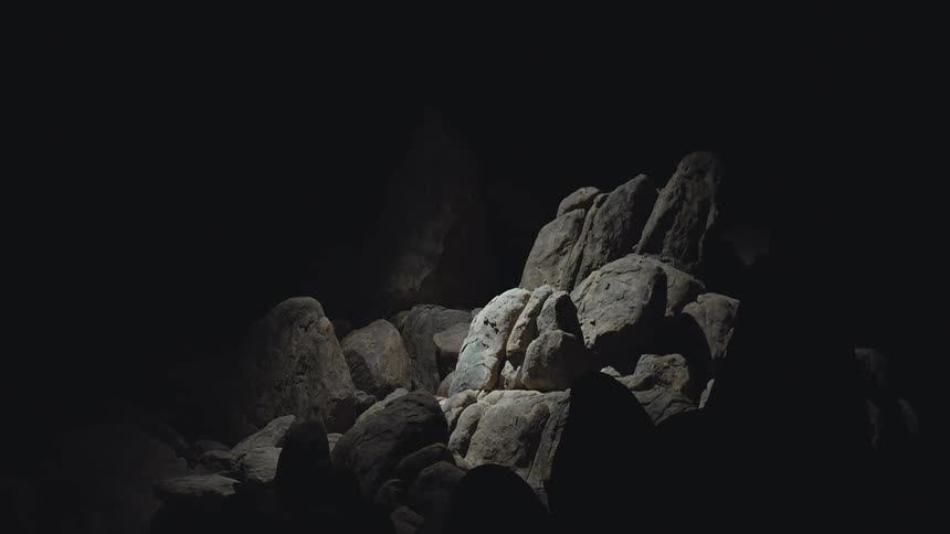 Light shines on the rocks in the cave search light helicopter drone light