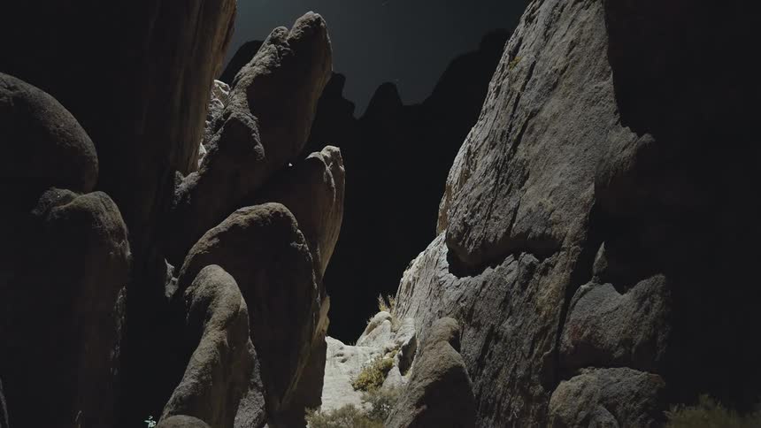 A time lapse of light moving across a rock formation throughout the day search light helicopter Drone light
