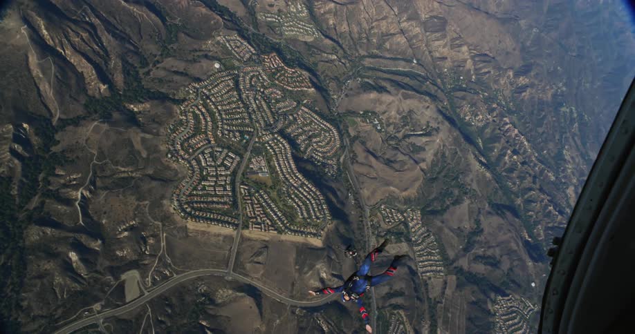 A point of view from inside an airplane as someone parachutes out
