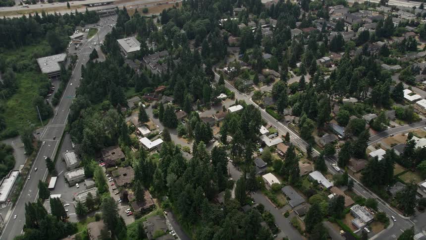 Aerial footage tilts down to showcase suburban homes and freeways near Bellevue Washington interchange during daytime