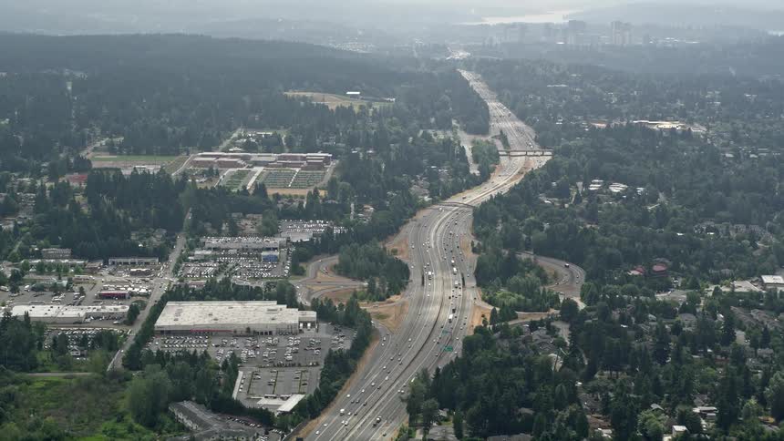 Aerial view of light traffic on Interstate 405 in Kirkland Washington surrounded by hazy hills and office buildings