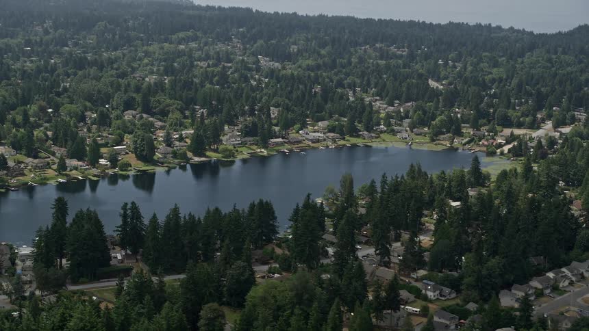 Fly over lakefront homes around Lake Serene in Lynnwood Washington on a sunny day