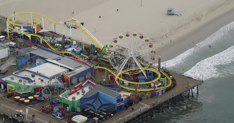 Aerial view of an amusement park in a pier on the coast at daytime