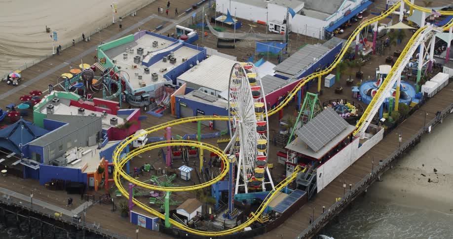 Aerial view of an amusement park in a pier on the coast at daytime