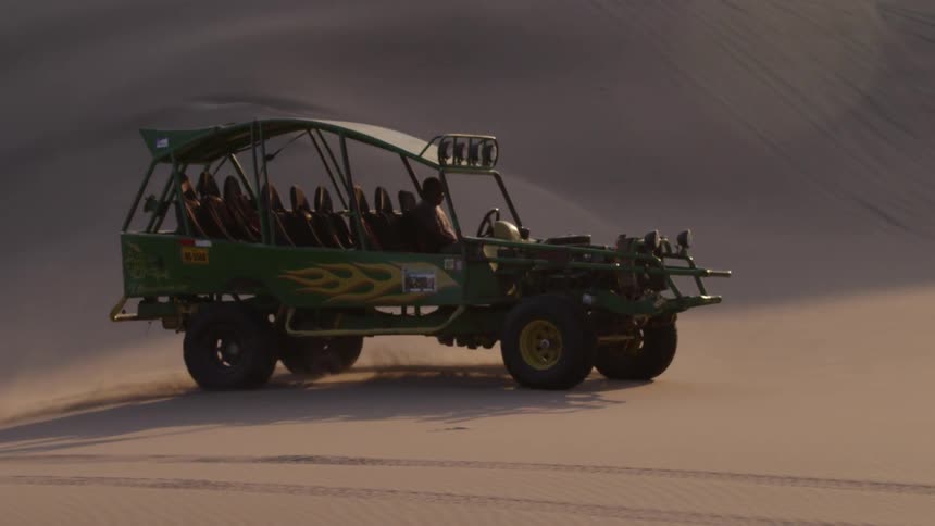 A large vehicle is driving in the desert