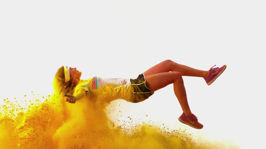 A woman flies through yellow powder