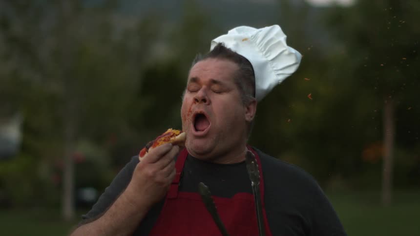 A man about to eat a hot dog has it blown in his face in extreme slow motion