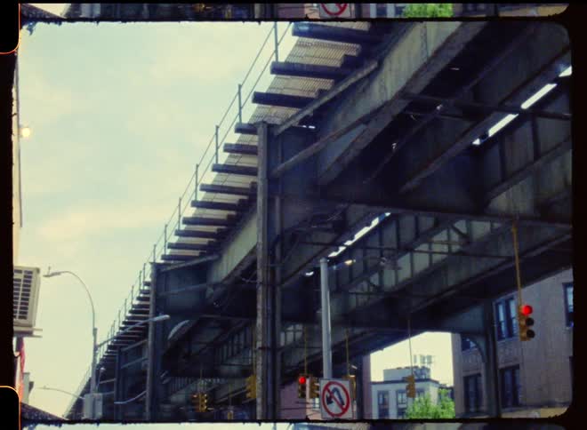 Film of an overpass roadway in a city with street lights underneath it