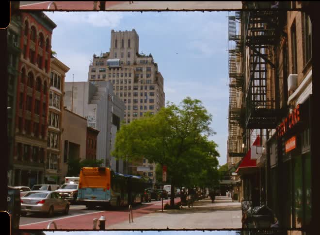Busy city during the day with traffic in the streets and tall buildings against the blue sky