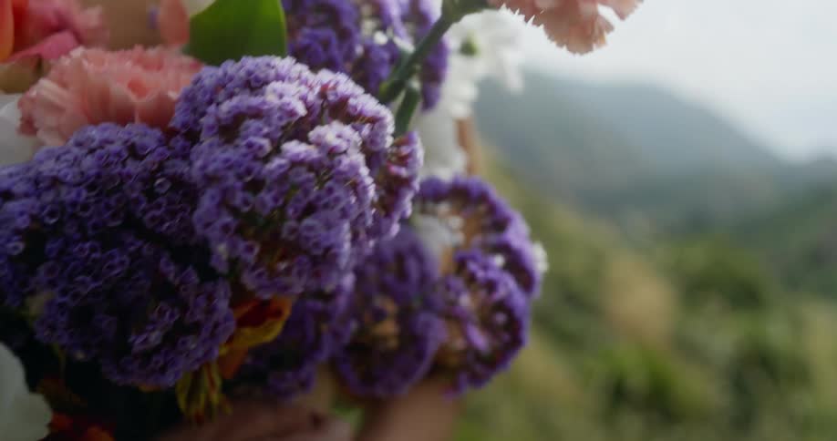 Close up of woman holding a bunch of flowers in the field