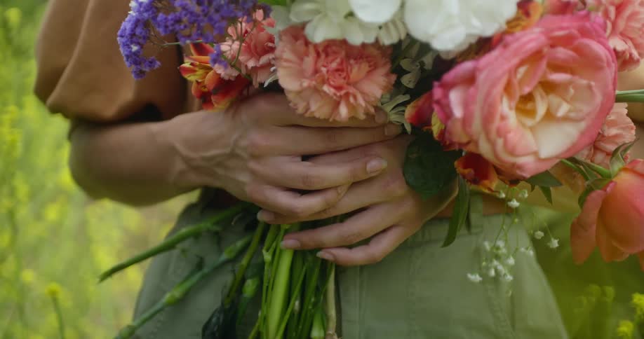 A woman is holding a bouquet of flowers