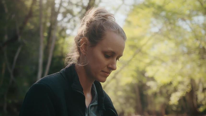 A woman is standing in the forest