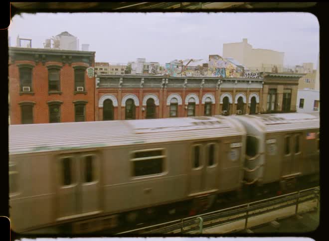Subway train on an elevated track through the city caught on vintage film